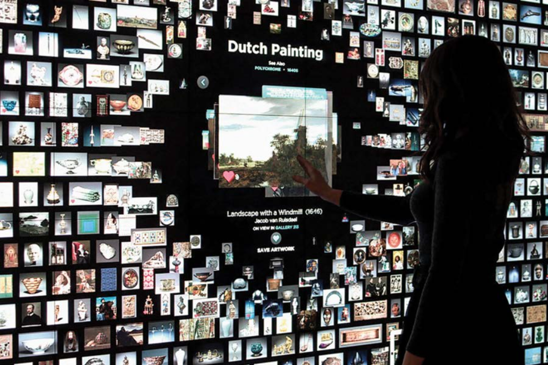 An image of a woman looking at a digital art exhibit.