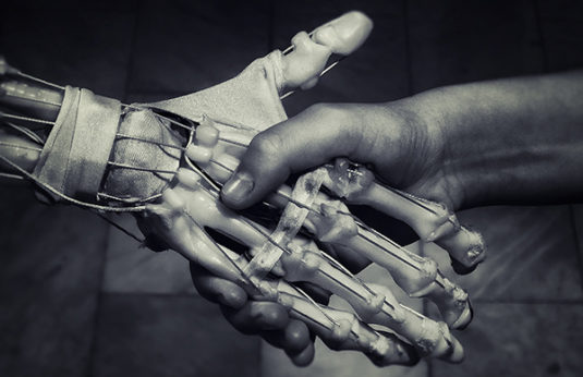 Image of a robot and human shaking hands