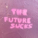 Photo of "the future sucks" spray painted on a pink wall
